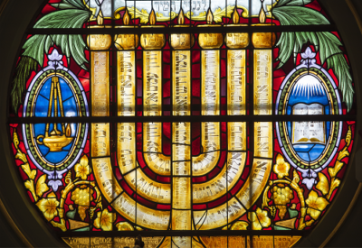 Colourful stained glass window with a menorah. The window belongs to Manchester Jewish Museum's synagogue.